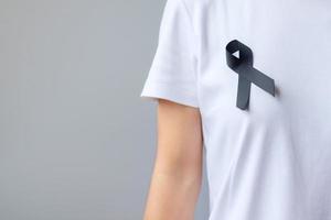 black Ribbon for Melanoma and skin cancer, Vaccine injury awareness month, grief and rest in peace. Healthcare and Racist concept photo