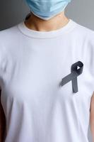 black Ribbon for Melanoma and skin cancer, Vaccine injury awareness month, grief and rest in peace. Healthcare and Racist concept photo