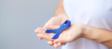 March Colorectal Cancer Awareness month, Woman holding dark Blue Ribbon for supporting people living and illness. Healthcare, hope and World cancer day concept photo