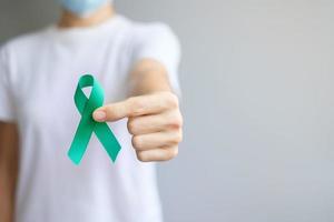 septiembre, mes de concientización sobre el cáncer de ovario, mujer con cinta de color verde azulado para apoyar a las personas que viven y enferman. conceptos de salud y día mundial contra el cáncer foto