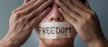 hombre con boca sellada en cinta adhesiva con mensaje de libertad. libertad de expresión, libertad de prensa, derechos humanos, dictadura de protesta, conceptos de democracia, libertad, igualdad y fraternidad foto