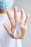 Woman holding white Ribbon for November Lung Cancer Awareness month, democracy and international peace day. Healthcare concept photo