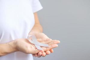 Brain Cancer Awareness month, woman hand holding grey color Ribbon for supporting people living. Healthcare and World cancer day concept photo