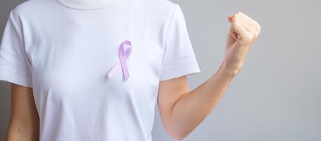 World cancer day. Woman hand holding Lavender purple ribbon for supporting people living and illness. Healthcare and medical concept photo