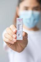 woman holding Rapid Antigen Test kit with Negative result during swab COVID-19 testing. Coronavirus Self nasal or Home test, Lockdown and Home Isolation concept photo