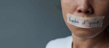 woman with mouth sealed in adhesive tape with Freedom  of Speech message., freedom of press, Human rights, Protest dictatorship, democracy, liberty, equality and fraternity concepts photo