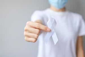 Woman holding white Ribbon for November Lung Cancer Awareness month, democracy and international peace day. Healthcare concept photo