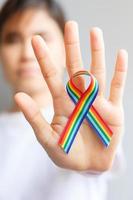 hand holding LGBTQ Rainbow ribbon for Support Lesbian, Gay, Bisexual, Transgender and Queer community and Pride month concept photo