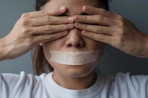 woman with mouth sealed in adhesive tape. Free of speech, freedom of press, Human rights, Protest dictatorship, democracy, liberty, equality and fraternity concepts photo