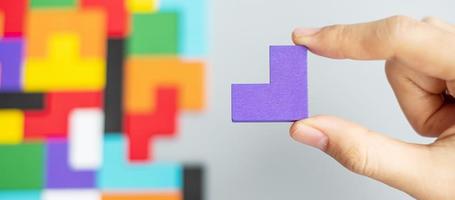 hand connecting geometric shape block with colorful wood puzzle pieces. logical thinking, business logic, Conundrum, decision, solutions, rational, mission, success, goals and strategy concepts photo