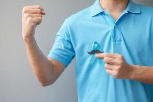 November Prostate Cancer Awareness month, Man holding Blue Ribbon with mustache for supporting people living and illness. Healthcare, International men, Father and World cancer day concept photo