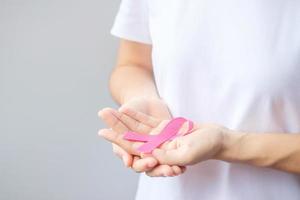 October Breast Cancer Awareness month, elderly Woman in white T- shirt with hand holding Pink Ribbon for supporting people living and illness. International Women, Mother and World cancer day concept photo