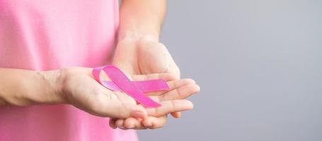 October Breast Cancer Awareness month, elderly Woman in pink T- shirt with hand holding Pink Ribbon for supporting people living and illness. International Women, Mother and World cancer day concept photo