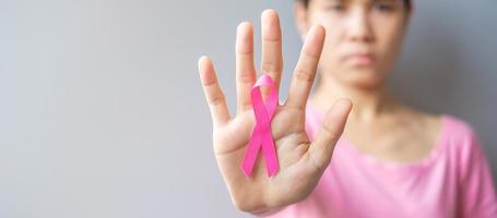 October Breast Cancer Awareness month, elderly Woman in pink T- shirt with hand holding Pink Ribbon for supporting people living and illness. International Women, Mother and World cancer day concept photo