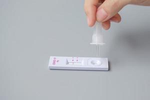 man swab COVID-19 testing by Rapid Antigen Test kit. Coronavirus Self nasal or Home test, Lockdown and Home Isolation concept photo