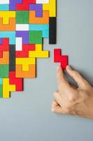hand connecting geometric shape block with colorful wood puzzle pieces. logical thinking, business logic, Conundrum, decision, solutions, rational, mission, success, goals and strategy concepts photo