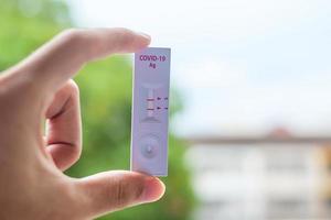 man holding Rapid Antigen Test kit with Positive result during swab COVID-19 testing. Coronavirus Self nasal or Home test, Lockdown and Home Isolation concept photo