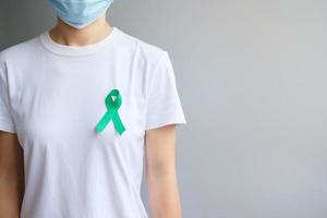 septiembre mes de concientización sobre el cáncer de ovario, mujer con color de cinta verde azulado para apoyar a las personas que viven y enferman. conceptos de salud y día mundial contra el cáncer foto
