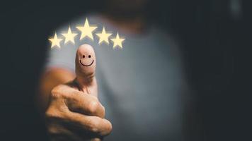 revisiones y comentarios de la experiencia del cliente y presentado con una calificación excelente de cinco estrellas. junto con un icono de cara sonriente en el pulgar del cliente, concepto de encuesta de satisfacción y espacio de copia. foto