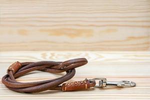 Pet leather leashes on wooden background photo