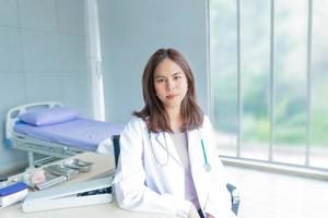 una doctora trabaja en una oficina en un hospital o clínica. sonrisa y mujer segura foto