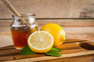 miel con limón sobre mesa de madera. nutrición saludable foto