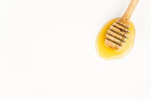 wooden honey dipper on white background photo