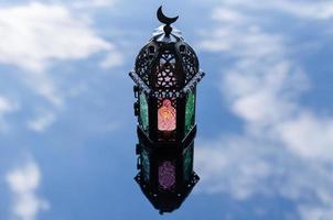 Selective forcus of lantern with reflection blurred background of cloud and sky for Islamic new year concept. photo