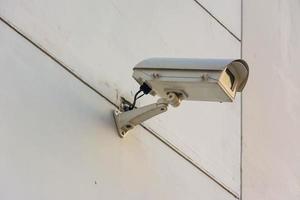 Three frontal view security cameras on a concrete wall. photo