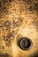 Old vintage retro compass on ancient map.The map used for background is in Public domain. photo