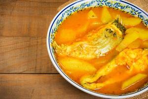 Southern Thai Spicy Sour Yellow Curry with Sea Bass and Coconut Shoots, Sour soup made of Tamarind Paste or Turmeric. photo