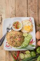 fried rice with vegetables, meat and fried eggs served on a plate with chopsticks photo