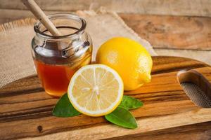 Honey with lemon on wooden table . Healthy nutrition photo