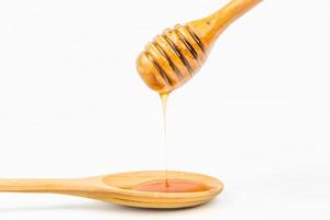 wooden honey dipper on white background photo