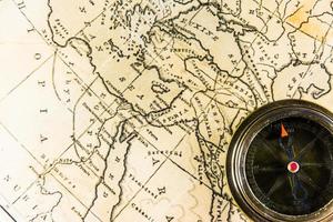 Old vintage retro compass on ancient map.The map used for background is in Public domain. photo