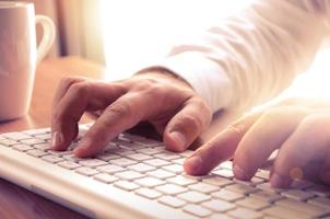 Closeup of mans hands typing on keyboard. photo