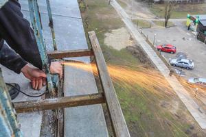 A worker cuts metal with a grinder. photo