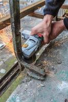 A worker cuts metal with a grinder. photo