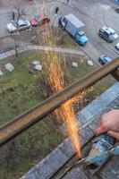 un trabajador corta metal con un molinillo. foto