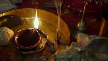 um close-up tiro de diya, lâmpada de óleo de barro com varas em chamas durante um ritual religioso na índia. video