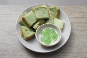 bread steamed custard in a white plate on a wooden table photo