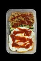 Fried eggs with sauce and minced pork in a plastic box. photo