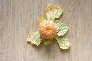 Peeled tangerines are placed on a wooden table. photo