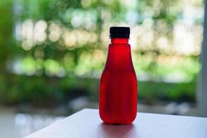 Roselle juice in a plastic bottle with nature green background photo