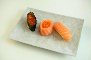 Three pieces of salmon sushi on a plate photo