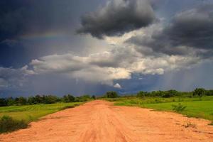 dirt road, cloudy sky and field photo