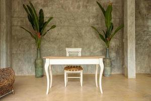 White wooden table and chairs in the living room with retro-style plaster walls. photo