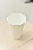 a paper cup on a wooden table photo
