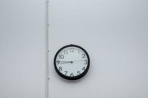 Black wall clock with white cement photo