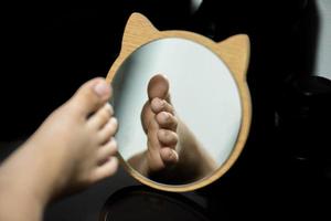 Feet in the mirror, wooden frame, animal shape with ears. photo